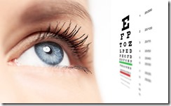 Close-up of woman blue eye with focus on pupil and eye vision chart on white background. Concept of ophthalmological test, cornea disease and therapy.